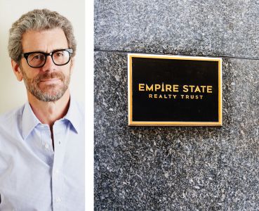 Anthony Malkin, CEO of Empire State Realty Trust, and their logo on a plaque.