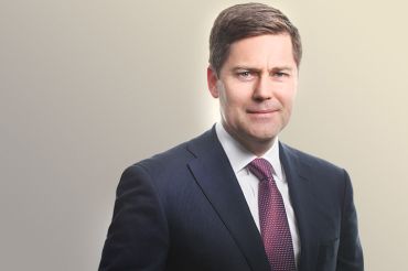 A man in a suit and tie smiling.