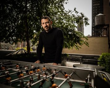 A man in front of a game called foosball.