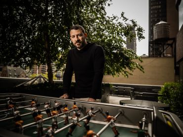 A man in front of a game called foosball.