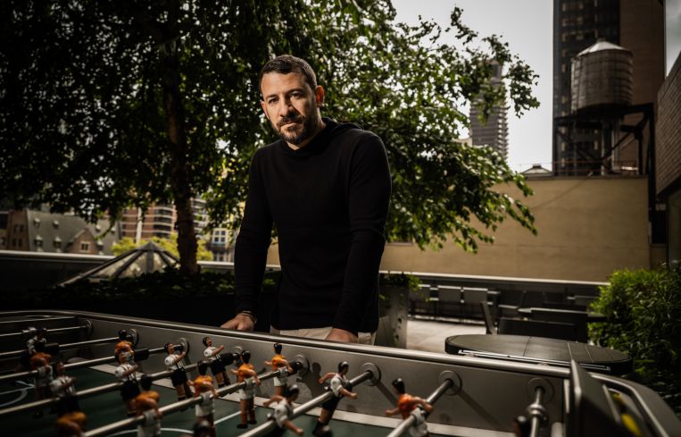 A man in front of a game called foosball.