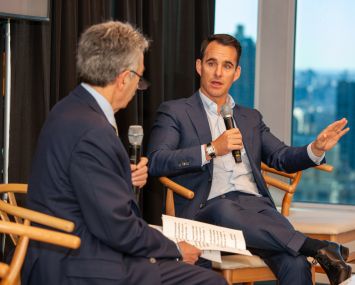 Two men chatting on a small stage.