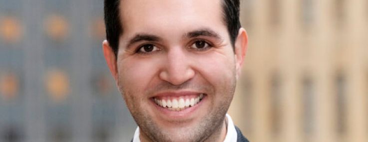 A man in a suit smiling.