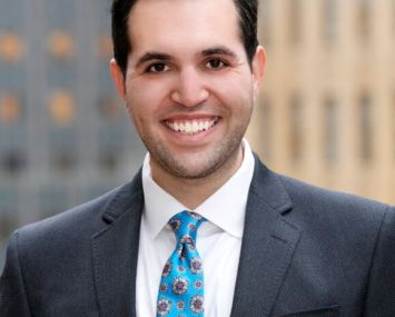 A man in a suit smiling.