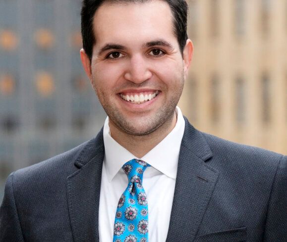 A man in a suit smiling.