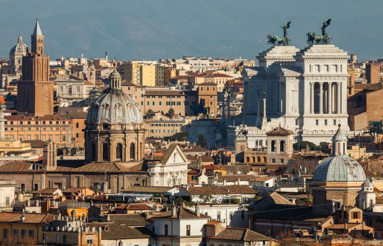 A view of Rome that includes older and newer buildings.