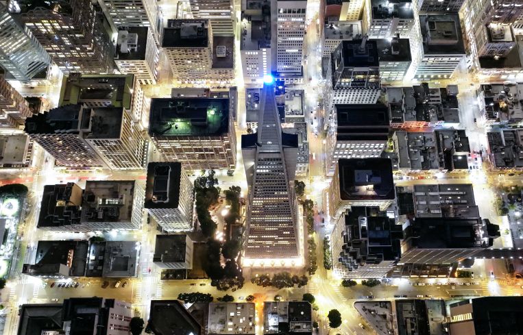 Aerial view of a city lighted up with buildings.