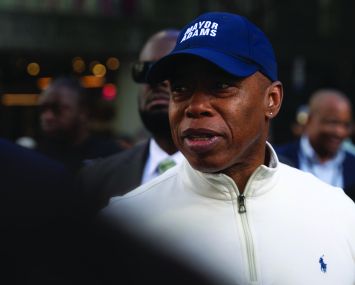 A man in a baseball cap surrounded by other people.
