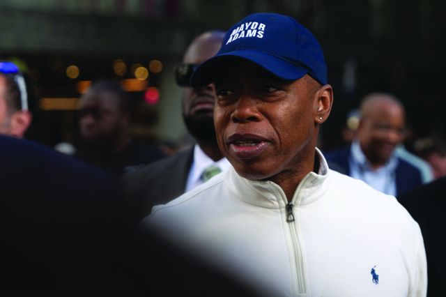 A man in a baseball cap surrounded by other people.