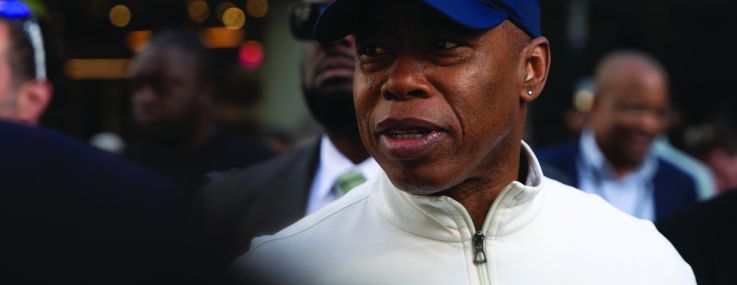 A man in a baseball cap surrounded by other people.