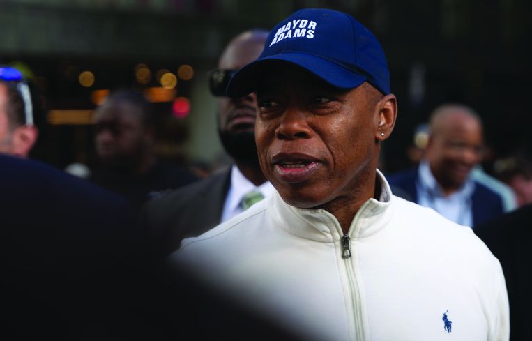 A man in a baseball cap surrounded by other people.