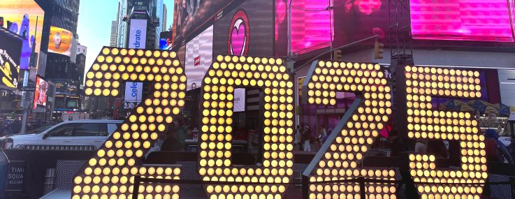 A lighted-up 2025 sign on an urban street.