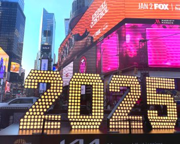 A lighted-up 2025 sign on an urban street.