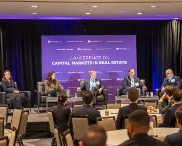 A photo of people sitting at a real estate pannel.