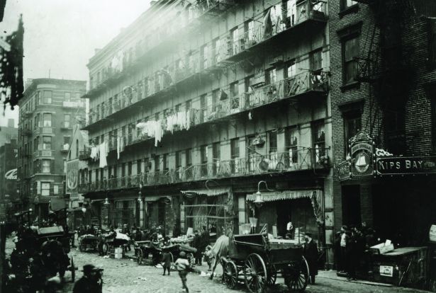 Hundreds of immigrant families do garment work for a living in tenement houses like this one on Elizabeth Street in Manhattan's Lower East Side. 1912. 