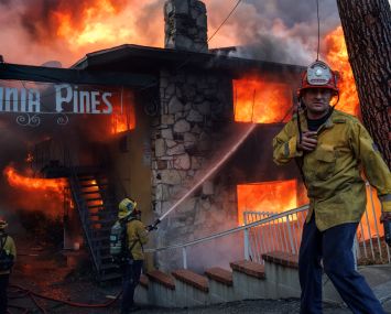 A Kern County fire captain directs his crews who are fighting an intense apartment fire blaze fueled by heavy winds from the Eaton fire on East Pine Street in Altadena, California.