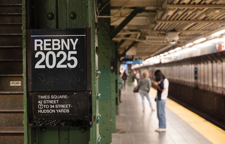 A subway platform with a sign "REBNY 2025."