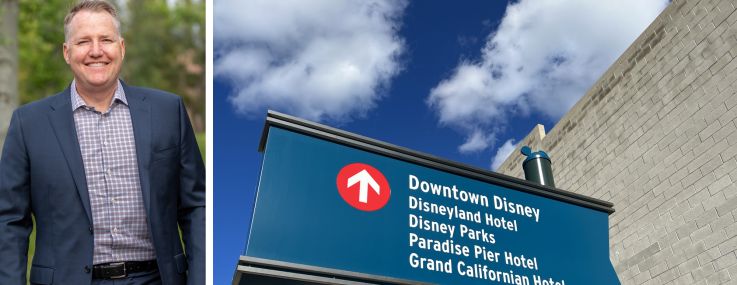 Dynamic City's chief investment officer Ryan Phelps and a sign directing people to hotels near Disneyland.
