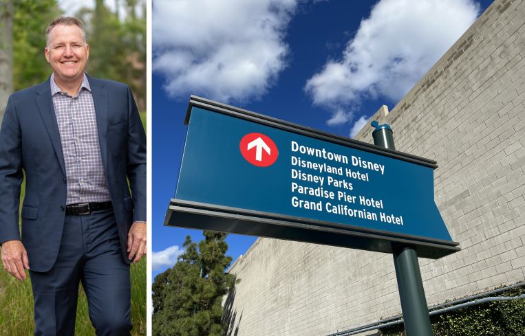 Dynamic City's chief investment officer Ryan Phelps and a sign directing people to hotels near Disneyland.