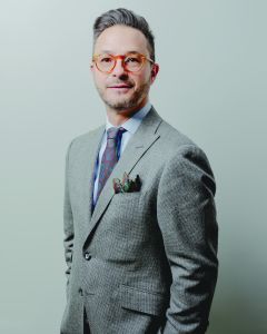 A man in glasses and a business suit. 
