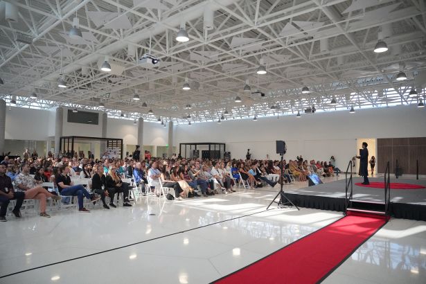 A man on a stage talking to people in seats in front of him. 