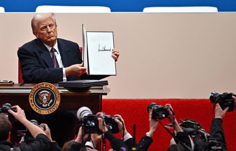 President Donald Trump signs executive orders inside Capital One Arena.