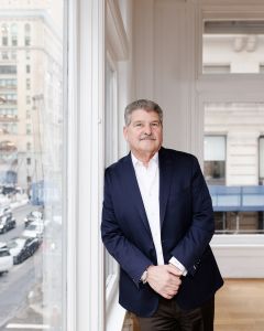 A man leaning up against an office window.