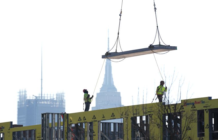 Construction workers on site with the Empire State Buiding in the background.