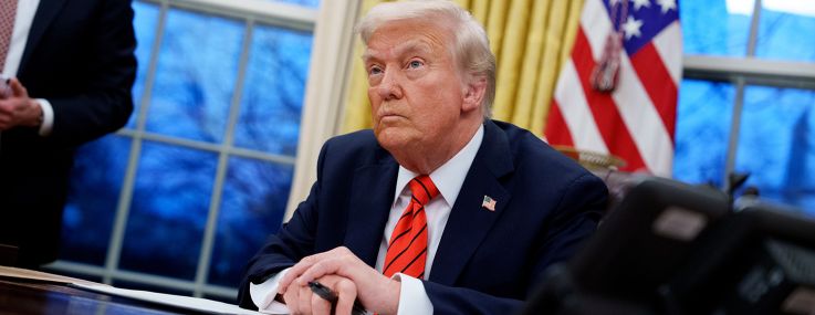 President Donald Trump sits at the Resolute Desk.