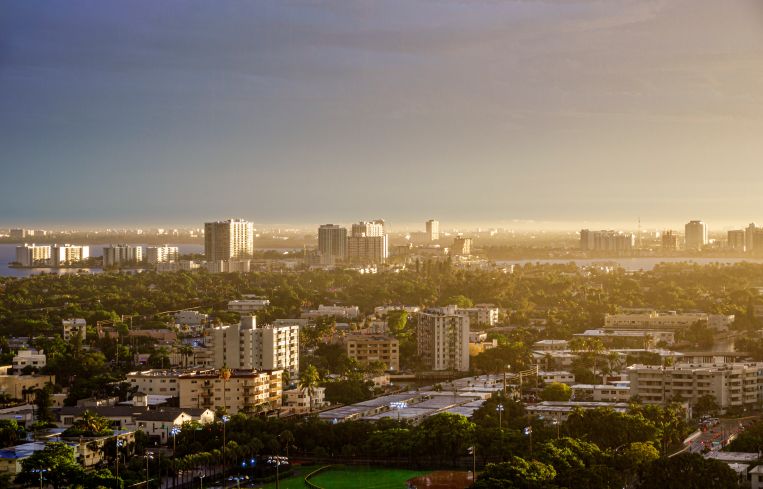 Miami Beach, Florida, aerial view looking down, city skyline buildings residences during break in stormy weather causing floods.