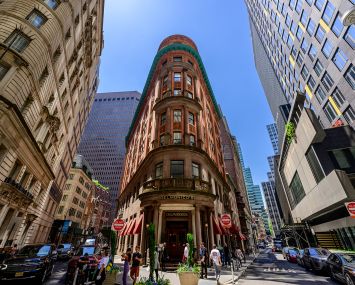 A triangular building amid a busy city landscape.