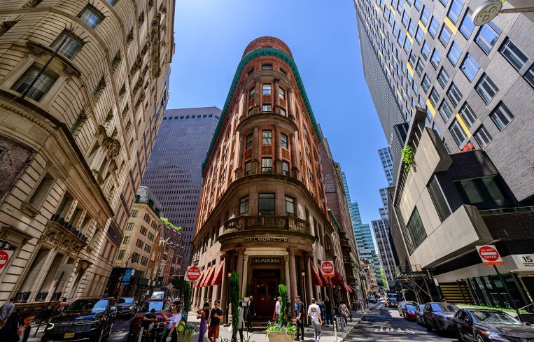 A triangular building amid a busy city landscape.