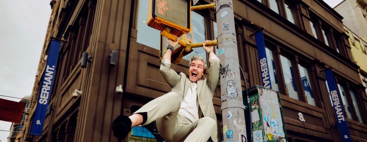 A man swinging from a streetlight post.