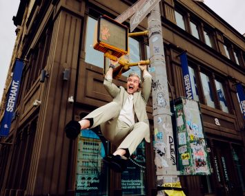 A man swinging from a streetlight post.