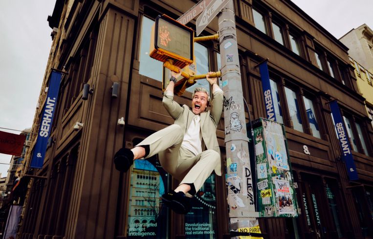 A man swinging from a streetlight post.