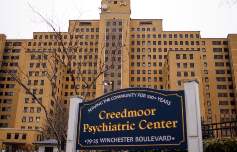 A looming building with a sign that says Creedmoor Psychiatric Center in front of it.