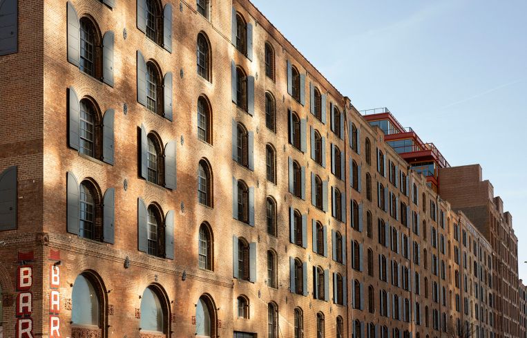 The sun's reflection casts light onto the side of Terminal Warehouse.