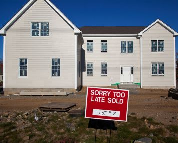 A newly built house with a sign in front of it that says "Sorry to Late Sold".