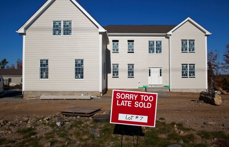 A newly built house with a sign in front of it that says "Sorry to Late Sold".