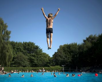 A photo of a kid jumping in the pool.