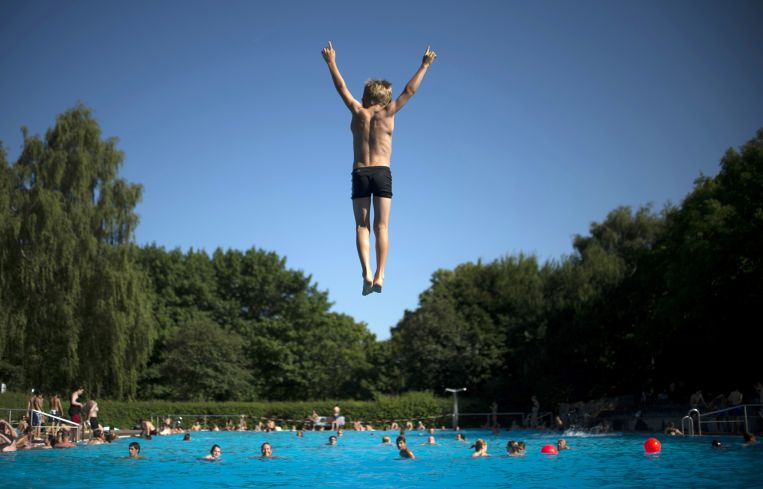 A photo of a kid jumping in the pool.
