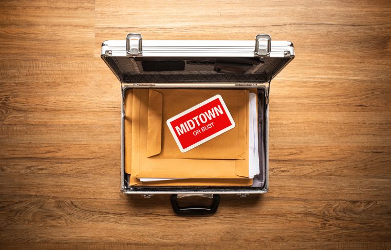 Opened briefcase with a memo that says Midtown on top of some folders.