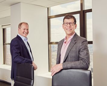 Two men standing in a conference room.