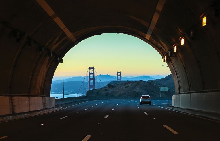 A tunnel ending with a big bridge beyond it.