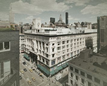 Aerial shot of a large building on a busy urban corner.
