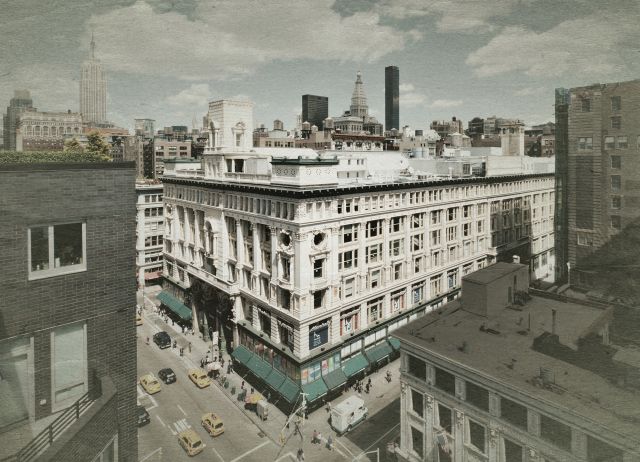 Aerial shot of a large building on a busy urban corner.