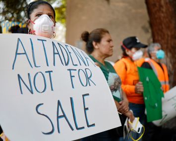 A person holds a sign which reads 'Altadena Not For Sale' at a tenants rally outside a fire-damaged apartment complex, which was damaged in the Eaton Fire, in Altadena, California.