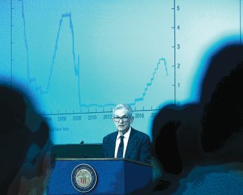 A man at a podium in front of a graph.