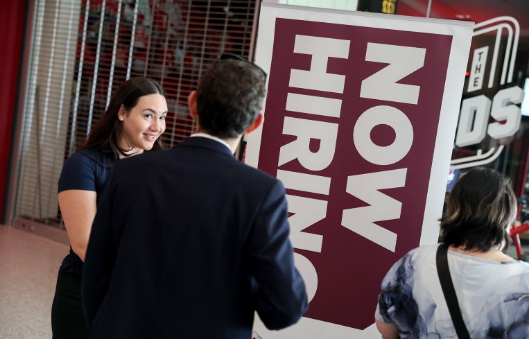 People wait in line at a job fair in Sunrise, Fla.