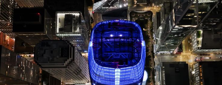 An aerial night view of Salesforce Tower and buildings in San Francisco.